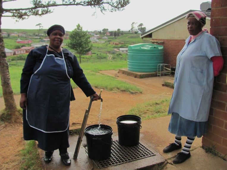 r mpop women filling buckets from tap